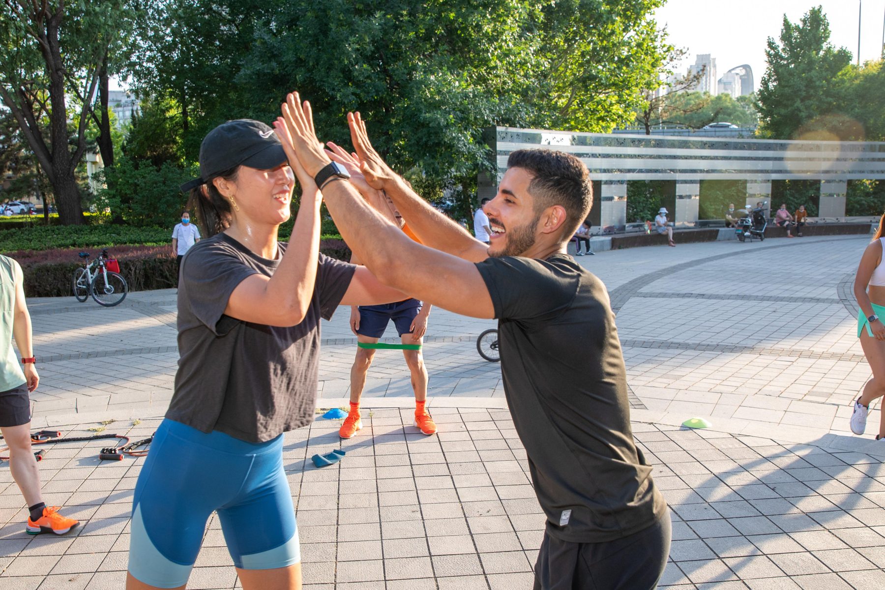 Angelo high-fiving a participant during an outdoor group workout