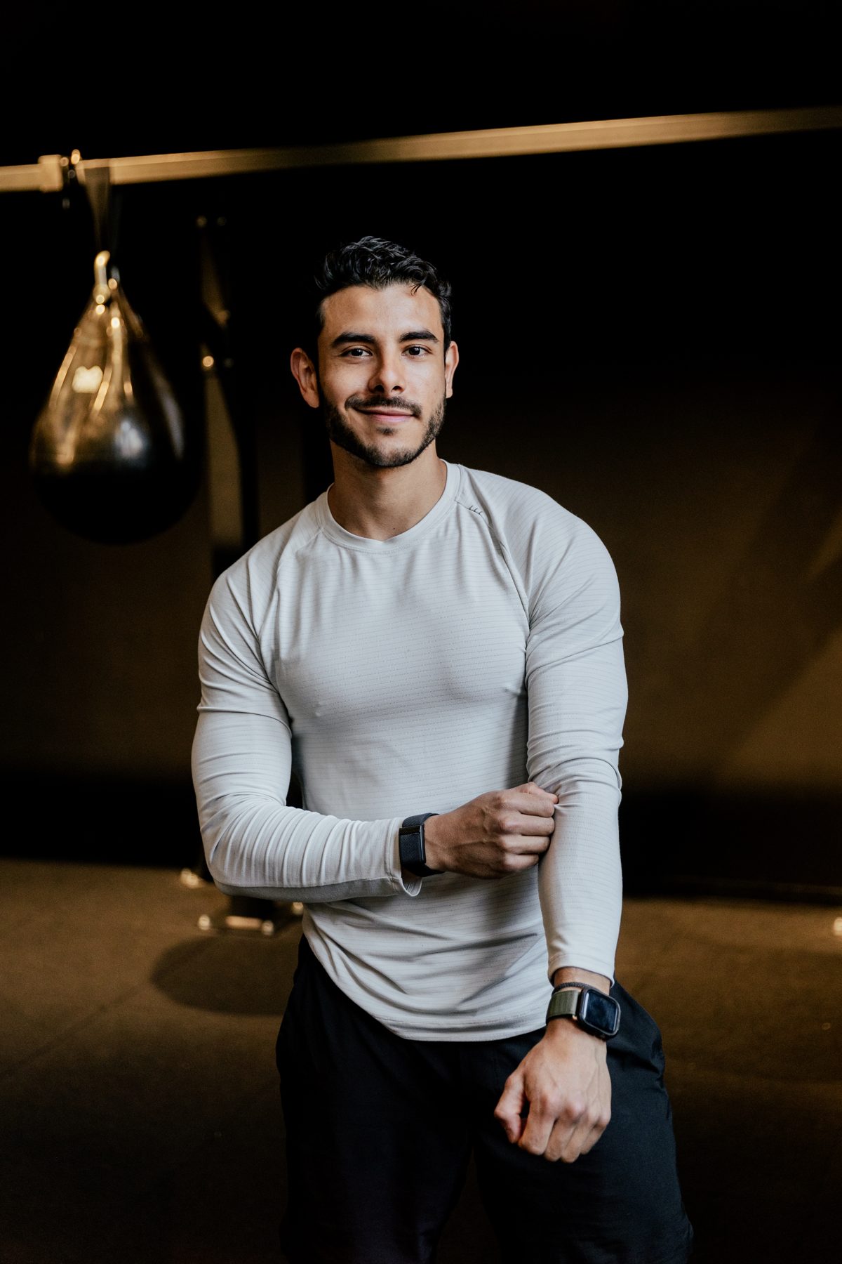 Angelo Eugenio in a dark gym, adjusting his sleeve